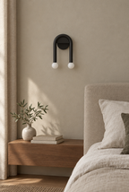 Svart bågformad vägglampa med två vita glober