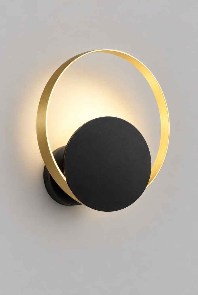 Vägglampa med guldfärgad ring och svart skiva
